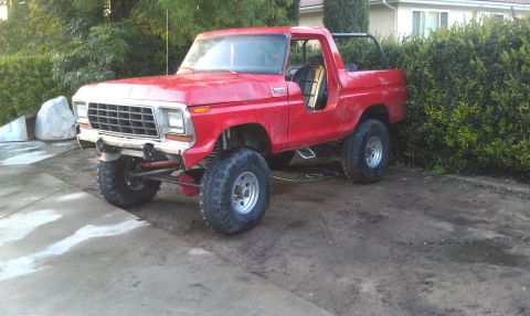 1978 Ford Bronco - A red 1978 Ford Bronco is shown with its doors removed and modified suspension.