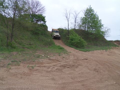 1989 Ford Bronco - A Jeep Wrangler navigates an off-road trail on a cloudy day.