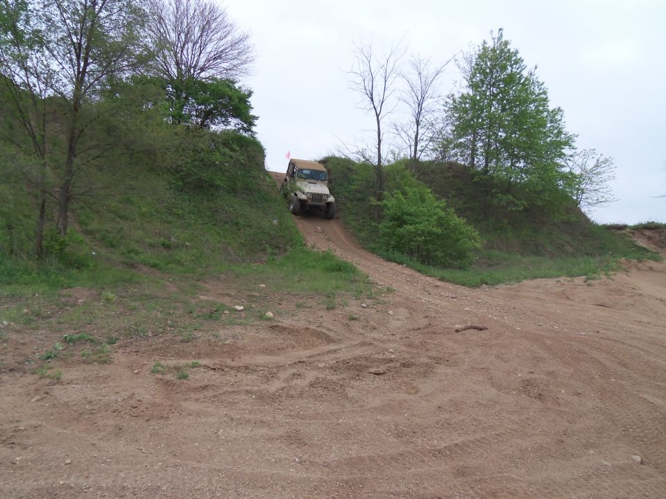 Jeep Wrangler driving up a dirt hill