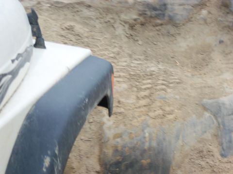 1989 Ford Bronco - Off-road vehicle navigating a sandy and rocky terrain.