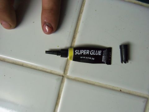 1968 Ford Bronco - A tube of super glue and its cap sit on a tiled surface near a finger with a damaged fingernail.