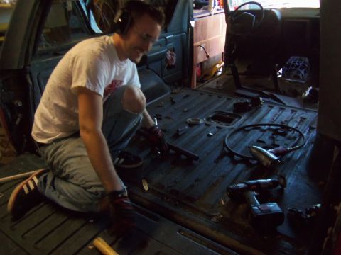 1968 Ford Bronco - Man is working on the interior of a vehicle, possibly a restoration project.