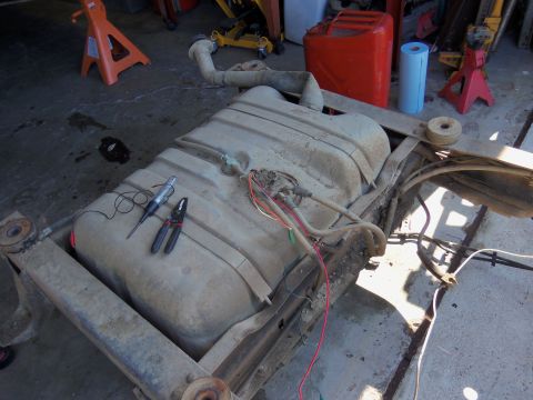 1968 Ford Bronco - Fuel tank assembly with wiring and tools, possibly for a 1968 Ford Bronco, is shown on a workbench.