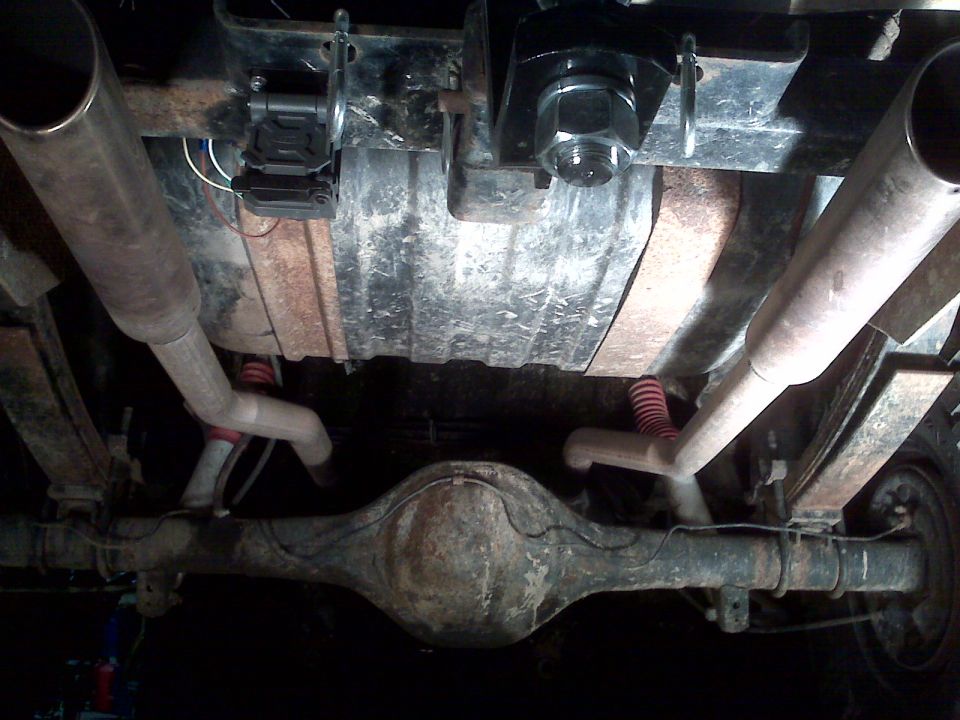 Undercarriage of 1978 Ford Bronco showing dual exhaust, fuel tank, and rear differential