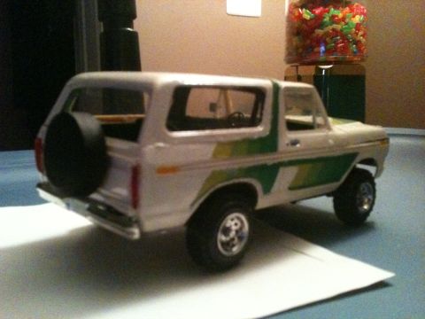 1979 Ford Bronco - This model Bronco features a white body with green accents and a rear-mounted spare tire.