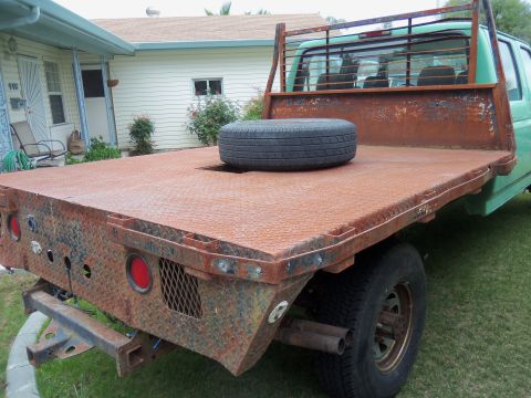 1968 Ford Bronco - This 1994 Ford F350 flatbed truck has a rusty bed and a spare tire. The album claims it is a 1968 Ford Bronco.