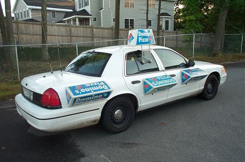 2001 Ford Crown Victoria - This 2001 Ford Crown Victoria is branded with Domino's Pizza advertisements for delivery.
