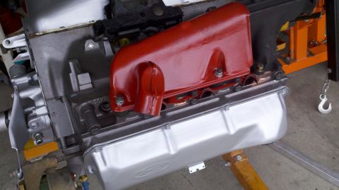 1978 Ford Bronco - Engine assembly with a red intake manifold and a shiny silver oil pan.