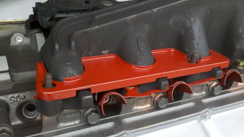 1978 Ford Bronco - Close-up of an engine intake manifold a red gasket and visible bolts. The number '35' is also visible on the engine block.