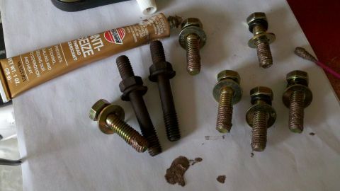 1978 Ford Bronco - Bolts and anti-seize lubricant laid out on a surface for a motor rebuild.