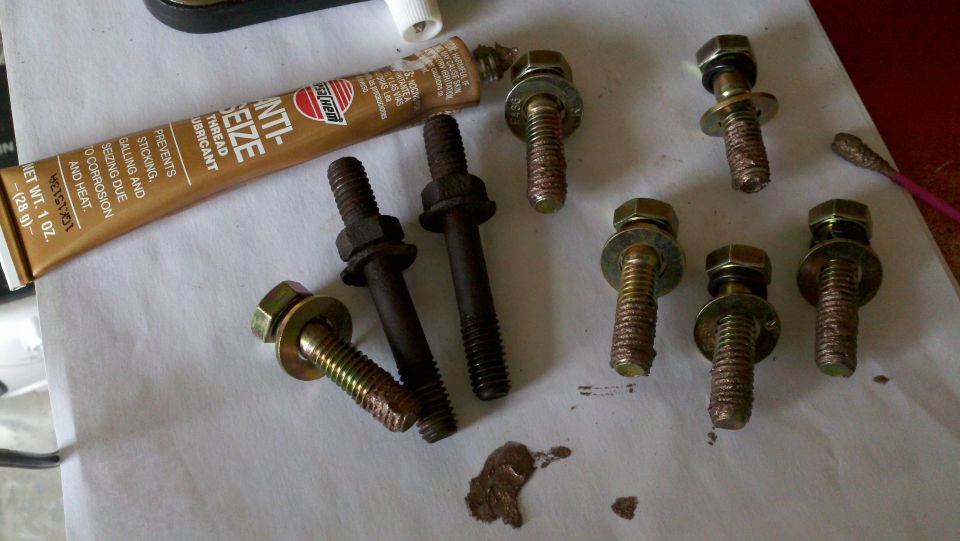 Several bolts with washers and a tube of Permatex Anti-Seize Lubricant