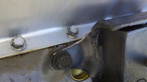 1978 Ford Bronco - Detail of an engine component, possibly from a motor rebuild, bolts and a SuperMotors watermark.