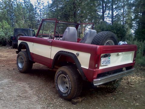 1968 Ford Bronco - A two-tone Ford Bronco sits parked outdoors with a spare tire in the cargo area.