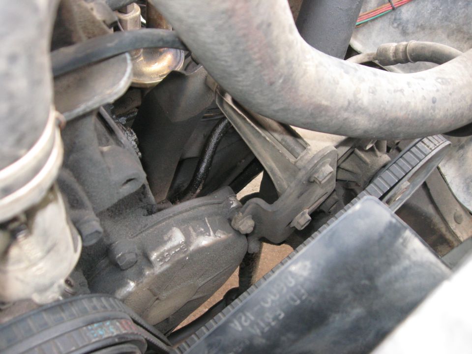 Close-up of engine components including hoses, belts, and brackets