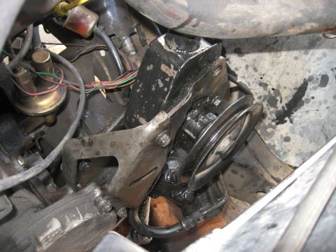 1981 Ford Bronco - Close-up view of a greasy power steering pump assembly within an engine bay.