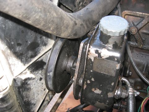 1981 Ford Bronco - Close-up of a vehicle's power steering pump and pulley assembly.