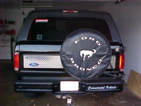 1995 Ford Bronco - The rear of a black 1995 Ford Bronco is shown, a spare tire cover and a diamond plate panel on the tailgate.