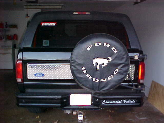 Rear view of black Ford Bronco with FORD BRONCO spare cover and diamond-plate tailgate