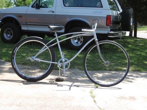 1994 Ford Bronco - A classic bicycle is parked in front of a lifted Ford Bronco.