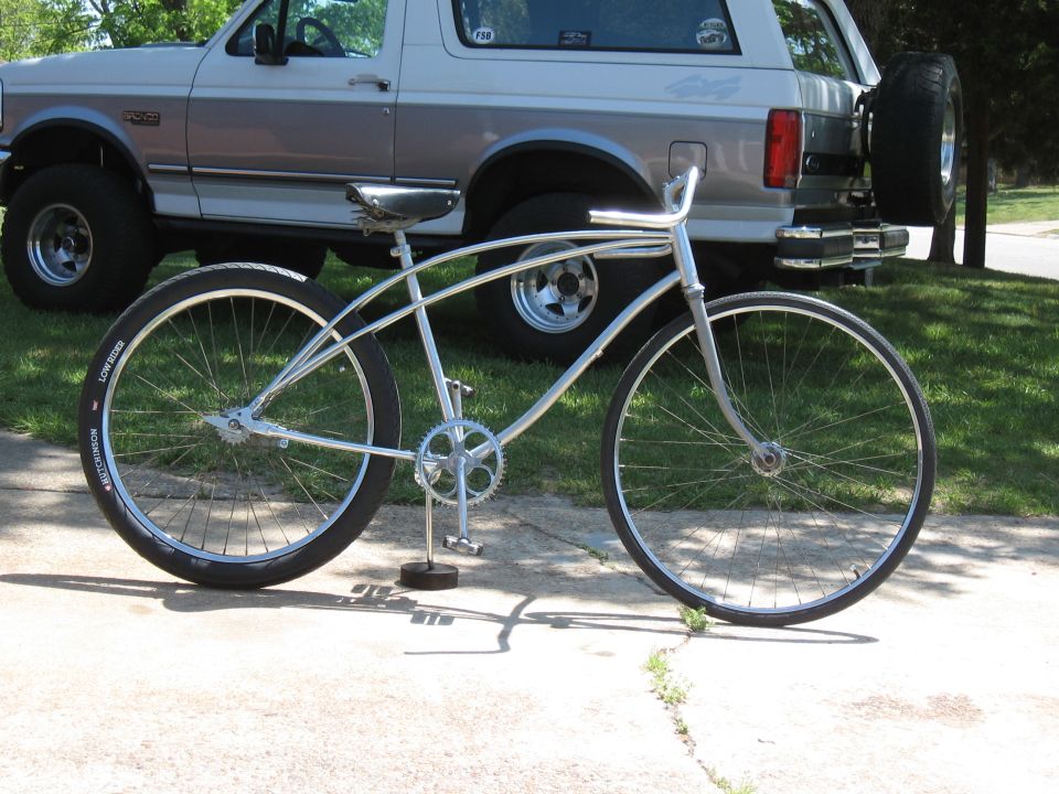 Silver bicycle in front of a two-tone 1992 Ford Bronco with a rear-mounted spare tire