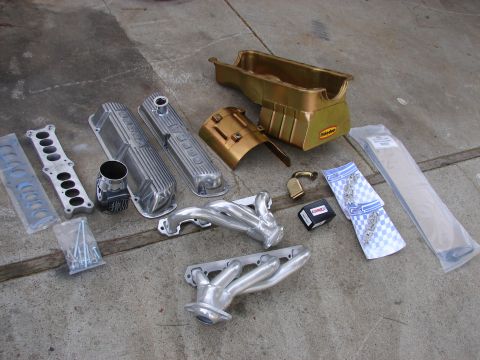 1973 Ford Ranchero - Various engine components are laid out on a concrete surface, suggesting a vehicle repair or upgrade.