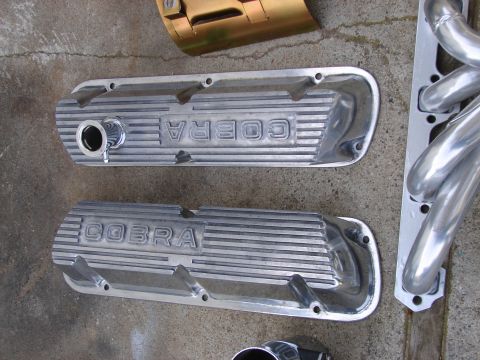 1973 Ford Ranchero - Engine parts, including Cobra valve covers and an exhaust header, are laid out on a concrete surface.