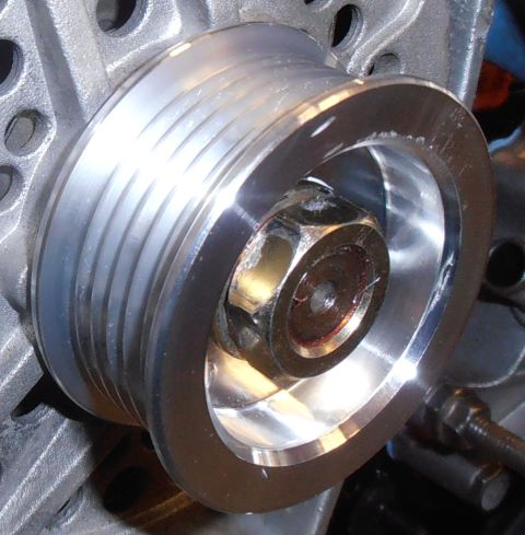 1990 Ford Bronco - A close-up view of a metal pulley assembly, likely from an engine compartment.