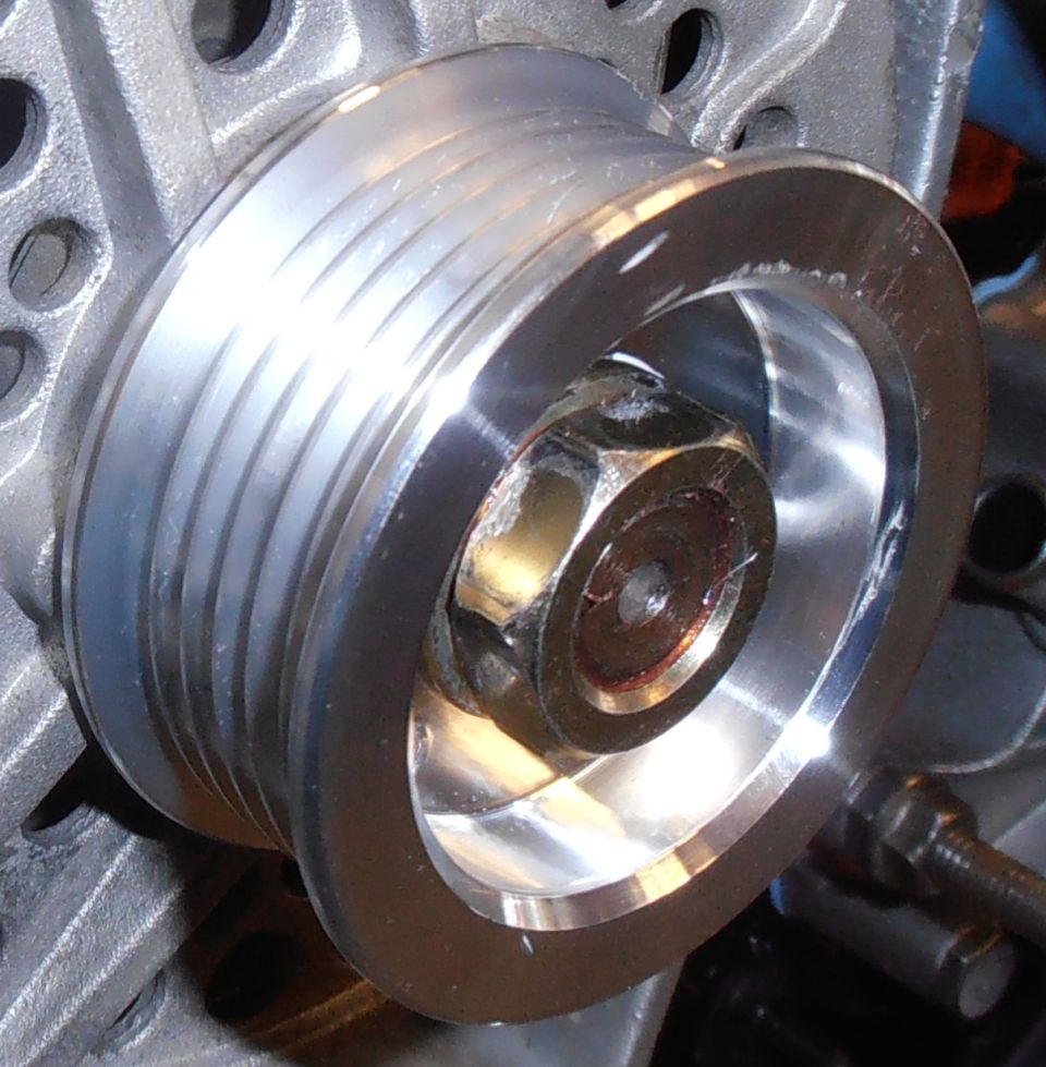 Close-up of a metal pulley with a hex bolt in the center