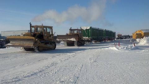 2009 Kenworth T800 - Bulldozers are seen in a snowy landscape, with one towing a long line of trailers.