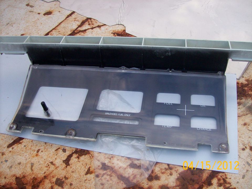 Gauge cluster bezel with cutouts for fuel, oil, temp, and charge gauges. Also has a cutout for the speedometer and a label for unleaded fuel only