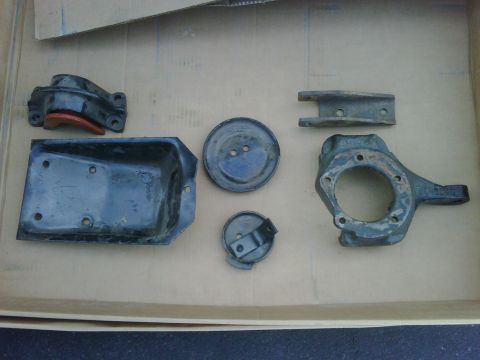 1996 Ford Bronco - Assorted metal automotive parts are displayed in a cardboard box.