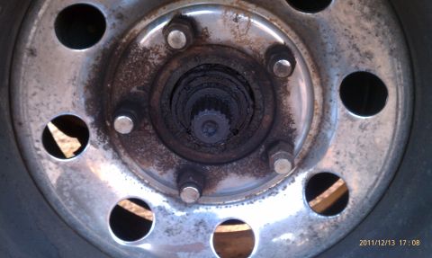 1987 Ford Bronco - Close-up view of a vehicle's wheel hub, showing lug nuts and the central splined shaft.