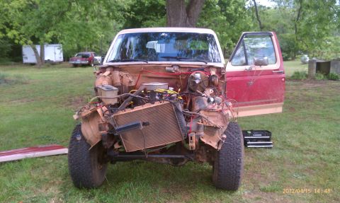 1987 Ford Bronco - Front end of a 1987 Ford Bronco with the engine and radiator removed, parked outdoors.