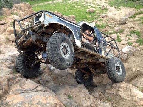 1986 Ford Bronco - This heavily modified 1986 Ford Bronco is tackling a challenging rocky terrain.