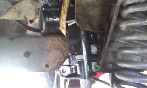 1978 Ford Bronco - This image shows a close-up view of a vehicle's steering gear assembly, including the gearbox and a portion of the suspension's coil spring.