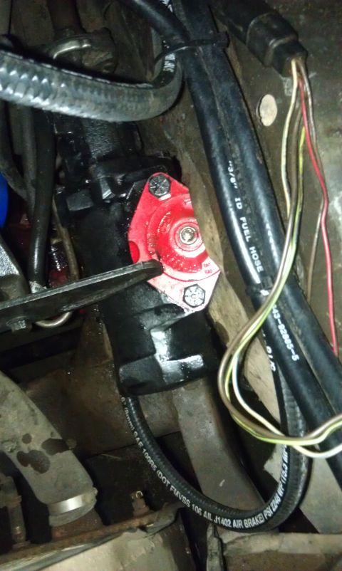 1978 Ford Bronco - Close-up view of a red steering component with hoses and wiring attached.