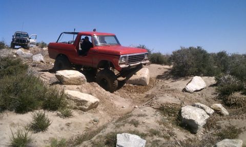 1978 Ford Bronco - 1978 Ford Bronco tackling an off-road trail with a second vehicle visible.