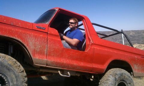 1978 Ford Bronco - This red 1978 Ford Bronco is equipped with a roll cage and appears to be used for off-road driving, as evidenced by the mud splatter.