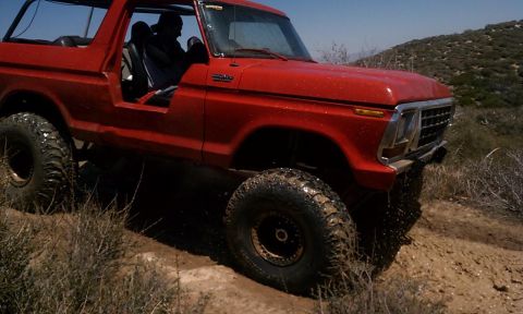 1978 Ford Bronco - This red 1978 Ford Bronco navigates a challenging off-road course with large tires and a lifted suspension.