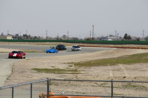 1995 Ford Taurus - Multiple vehicles are seen on a race track during what appears to be a track day event.