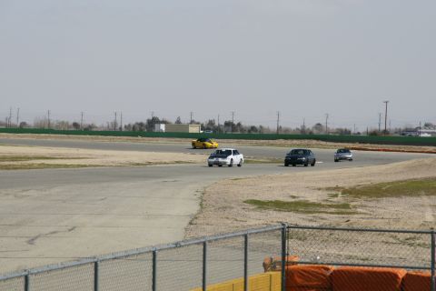 1995 Ford Taurus - Multiple cars are seen on a race track under a hazy sky.