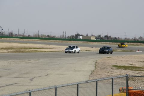 1995 Ford Taurus - Cars on a race track during a sunny day.