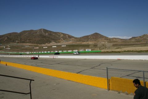 1995 Ford Taurus - Cars on a race track with mountains in the distance under a clear blue sky.