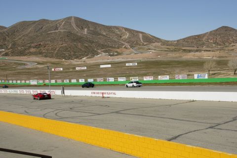 1995 Ford Taurus - Several cars are on a race track, with a mountain range visible behind the course.