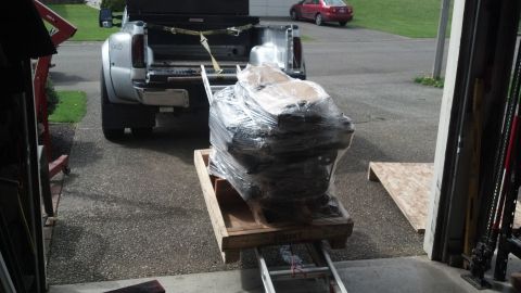 2008 Jeep Wrangler - Engine being loaded into a dually pickup truck, with a red car parked in the driveway.