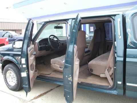 1999 Ford Ranger - Interior view of a green crew cab truck, revealing the front and rear seating areas with all doors ajar.