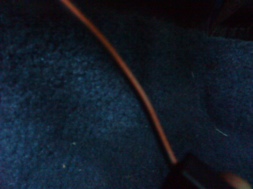 Orange wire against dark blue carpet