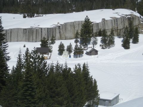 1986 Ford Bronco - A winter scene with cabins and trees under a rocky cliff face.