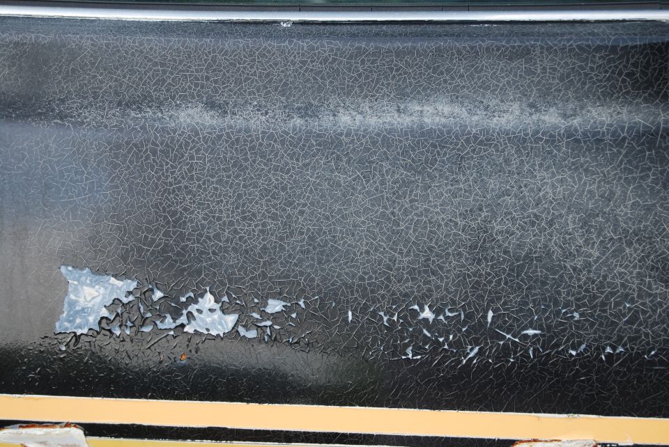 Cracked black paint on a 1975 Ford Ranchero panel
