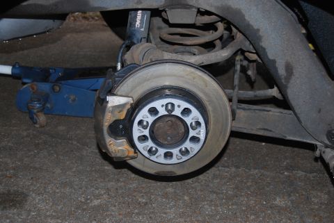 1975 Ford Ranchero - Close-up of a vehicle's rear disc brake assembly, showing wheel spacers and a jack.